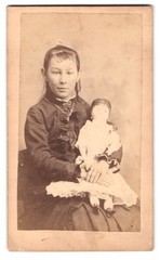 Photography of a girl with a large doll on her lap