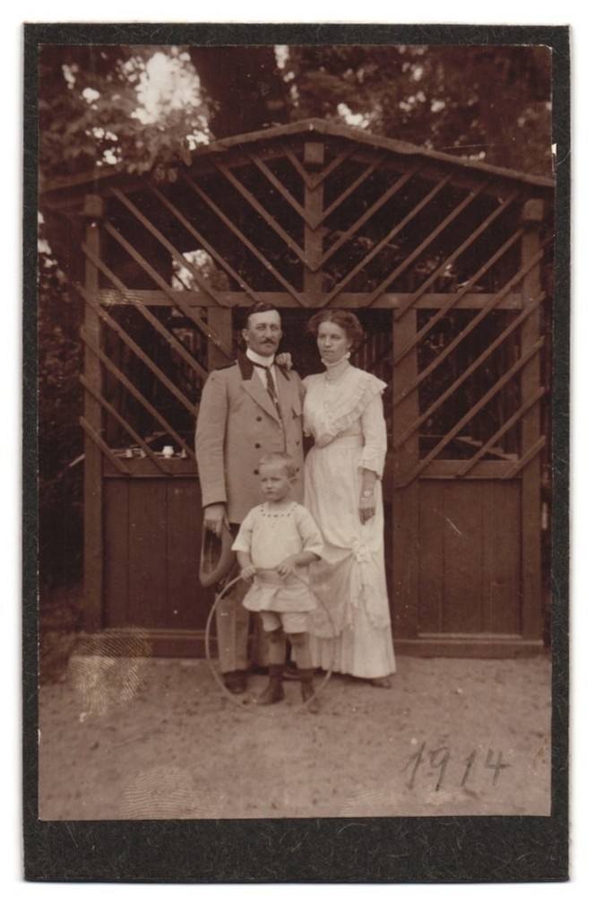 Photography of a family in the garden in front of a wooden gazebo