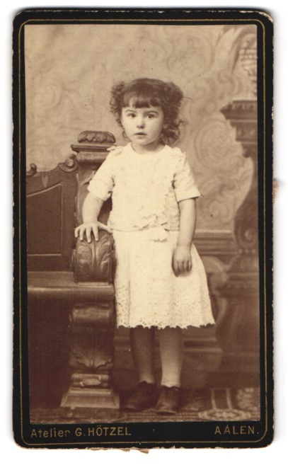 Photograph G. Hötzel, Aalen, girl in white dress next to ornate furniture