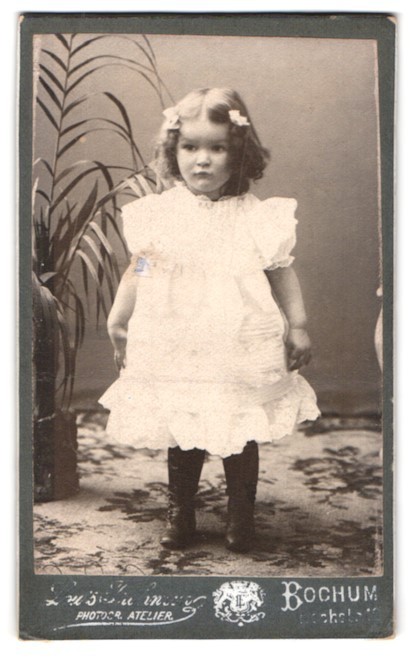 Photography Bochum, child in white dress in front of plant
