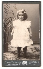Photography Bochum, child in white dress in front of plant