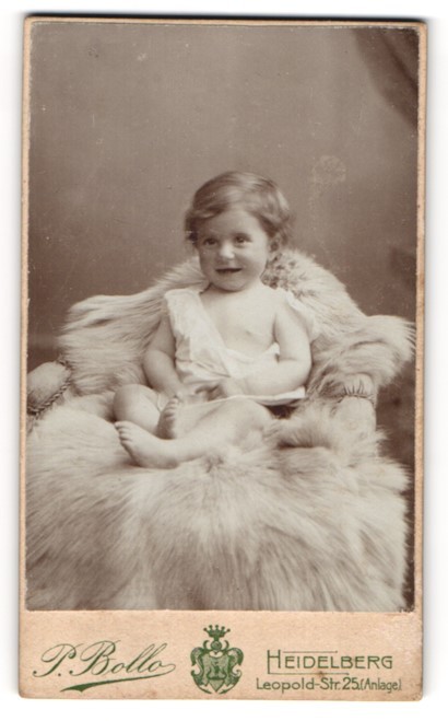 Photograph P. Bollo, Heidelberg, Leopold-Str.25, smiling child on fur cover