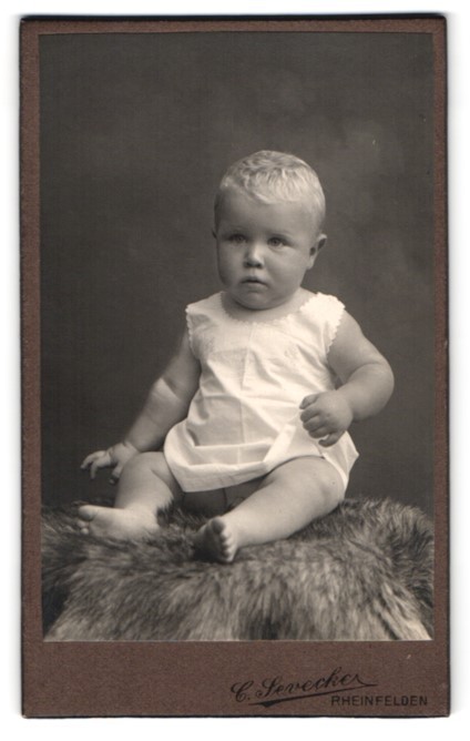Photograph by C. Sevecke, Rheinfelden, toddler Dölfi Bröden draped on fur, 1